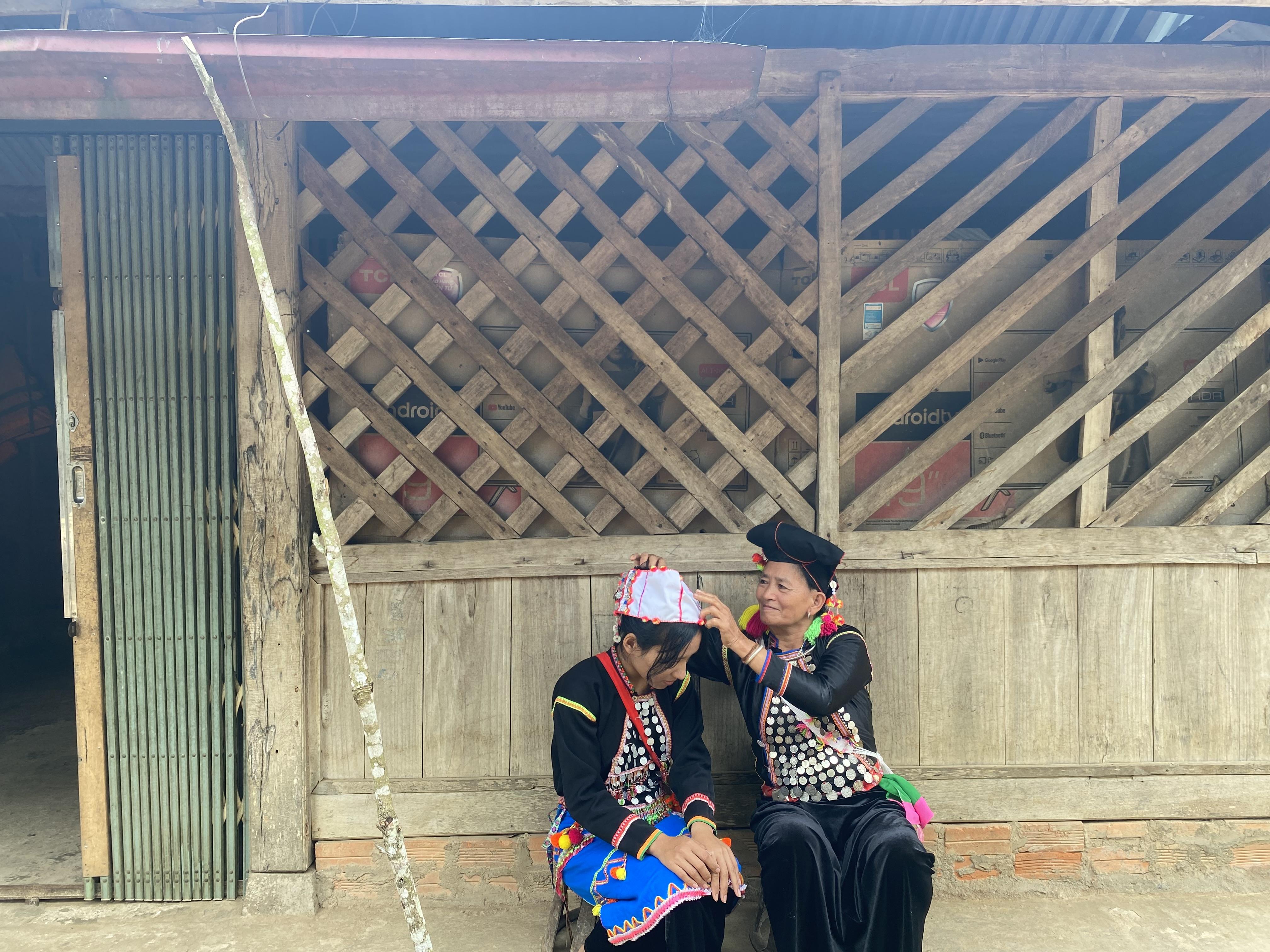 Bà quấn khăn đội đầu cho cháu